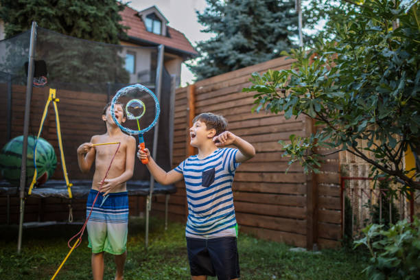 istock Boys having fun in yard with Soap Bubbles 1251240536