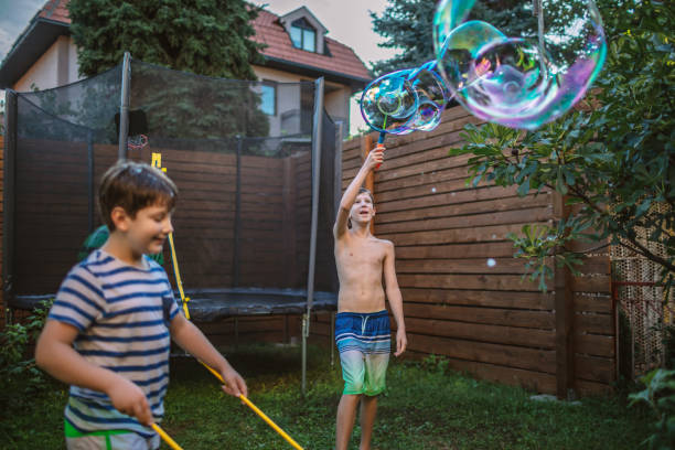 istock Boys having fun in yard with Soap Bubbles 1251241452