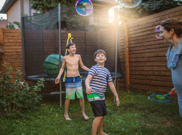 istock Mother and boys having fun in yard with Soap Bubbles 1251242421