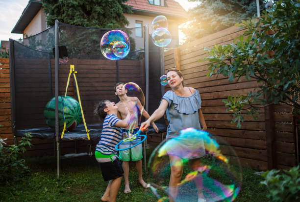 istock Mother and boys having fun in yard with Soap Bubbles 1251242971
