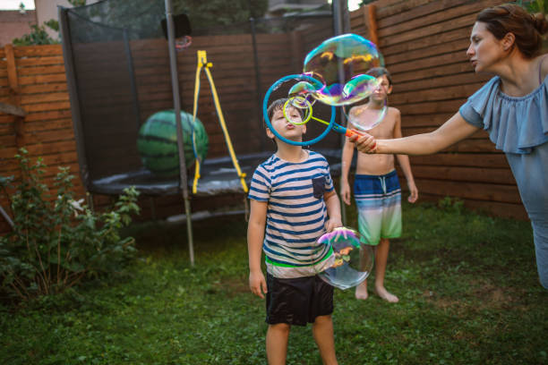 istock Mother and boys having fun in yard with Soap Bubbles 1251243240