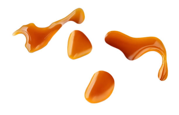 istock Sweet caramel sauce drops isolated on white background, top view 1251244794