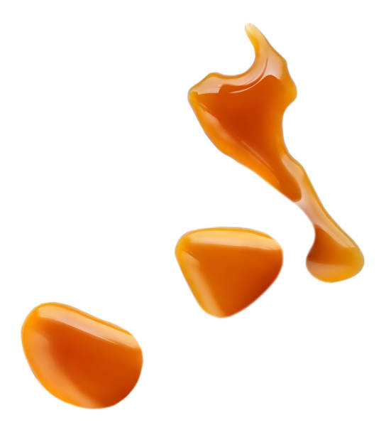 istock Sweet caramel sauce drops isolated on white background, top view 1251244799