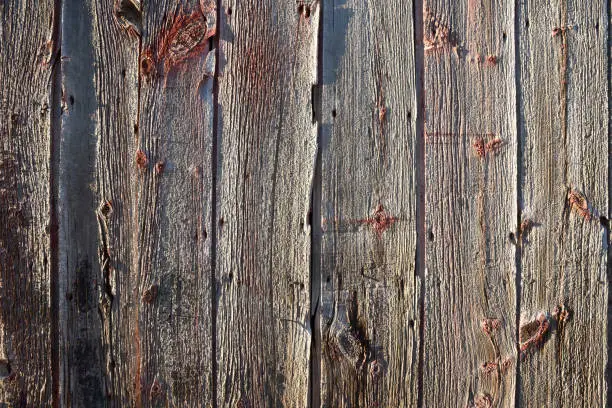 The exterior wall of a very old very weathered barn.