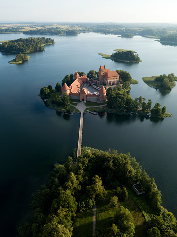 Aerial view of Medieval Trakai castle on green island in Galve lake, early morning sunrise. Lithuania popular historic landmarks. Europe UNESCO world heritage site. Drone photography