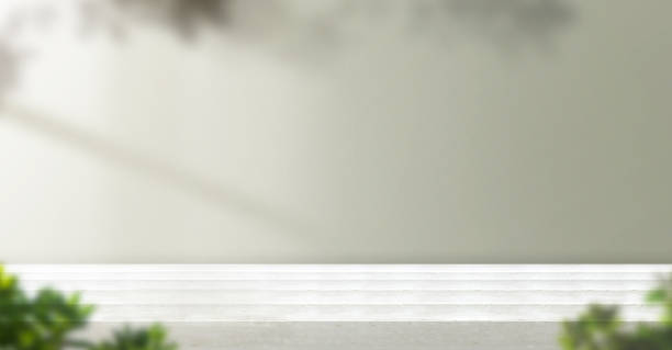 white wood table background with leaf shadow on wall and plant at home