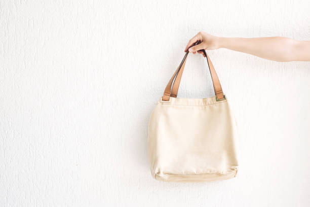 istock Hand holding linen bag on wall background . 1251253162