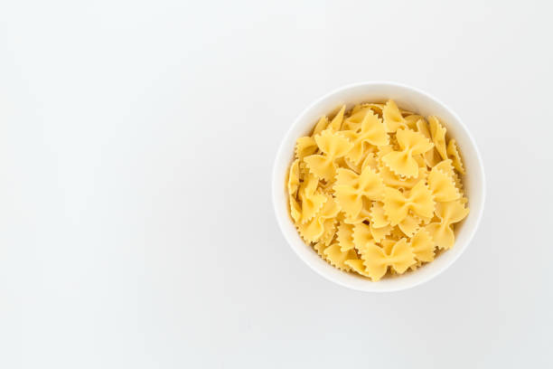 istock Bowl of uncooked pasta isolated on a white background 1251255676