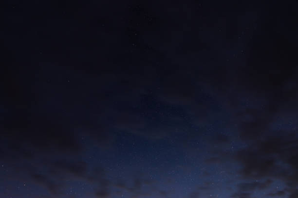 Stars in the night sky through the clouds on a summer night