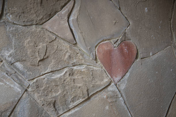 Stone wall cladding. Among the usual forms, there is a heart-shaped stone. Declaration of love. A symbol