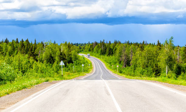 istock Bright rainbow over the highway and summer forest. After a thunderstorm 1251258077