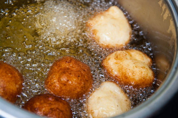istock Homemade donuts making boiling in hot oil 1251261403