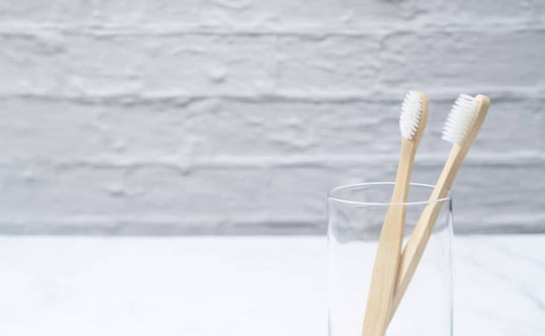 istock A bamboo toothbrush in a cup set against a marble background 1251262057