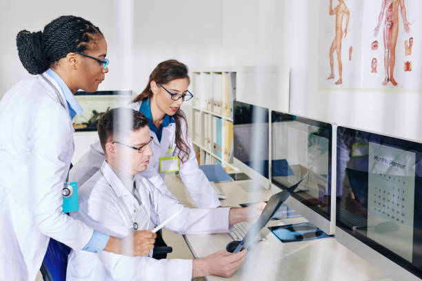 Medical workers discussing chest x-ray Group of young serious medical workers gathered to discuss chest x-ray of patient with suspected coronavirus health technology photos stock pictures, royalty-free photos & images