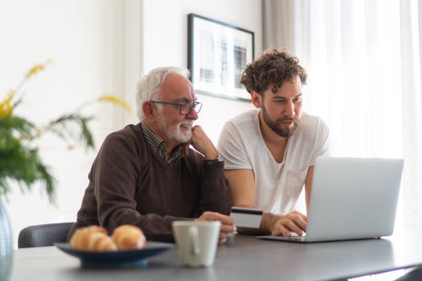 istock Grown son and senior dad using laptop 1251263908