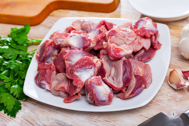 istock Raw chicken gizzards  before cooking on table with greens 1251265641