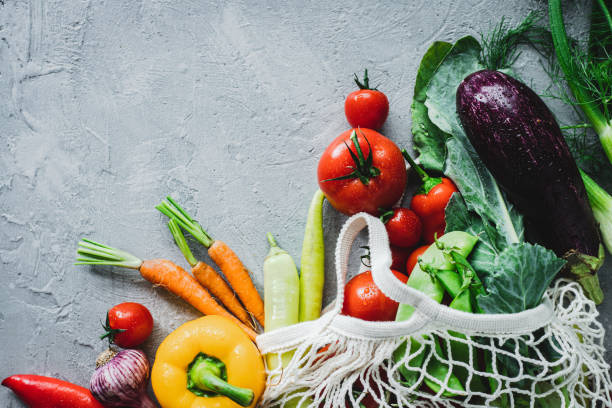 Fresh vegetables on grey background Directly above shot of fresh vegetables in shopping bag. Fresh and healthy groceries on grey background. pile of carrots stock pictures, royalty-free photos & images