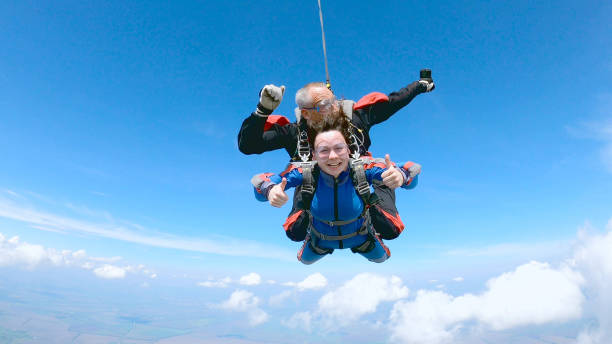istock Happy woman enjoy free fall with experienced parachuting instructor. 1251268697