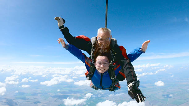 istock Happy woman enjoy free fall with experienced parachuting instructor. 1251268699