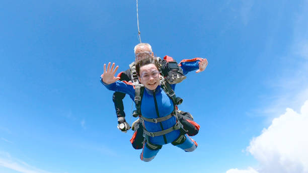 istock Happy woman enjoy free fall with experienced parachuting instructor. 1251268714