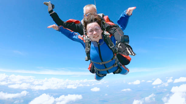 istock Happy woman enjoy free fall with experienced parachuting instructor. 1251268724