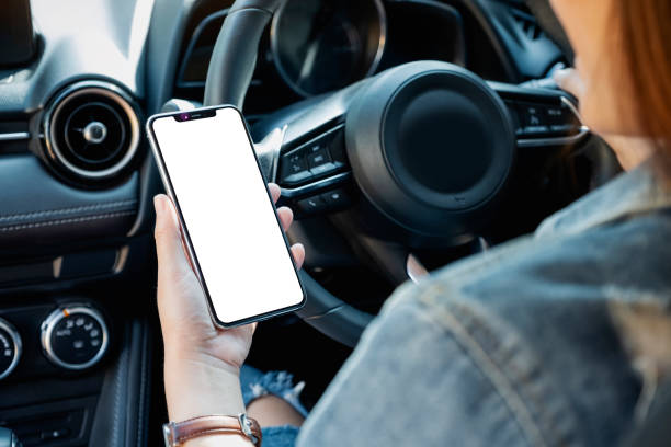 uma mulher segurando e usando o celular com tela em branco enquanto dirigia carro - driving mobile phone car talking - fotografias e filmes do acervo
