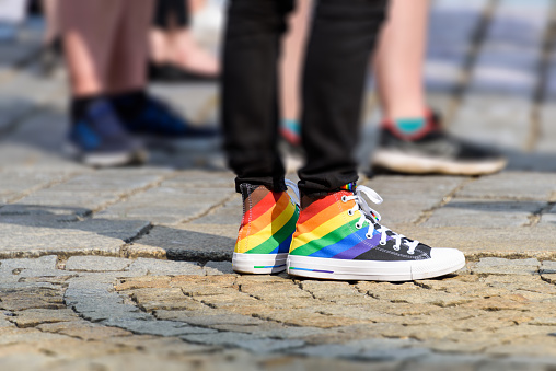 legs of young man in a sneakers with rainbow symbol of LGBT. LGBTQ+