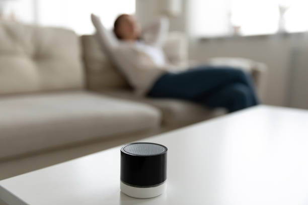 istock Woman listening music using mini portable speaker located on table 1251273773