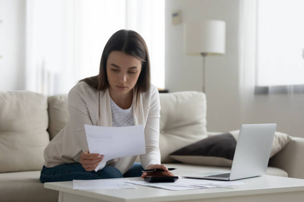 istock Bookkeeper working with invoices, calculates expenses doing work at home 1251273777