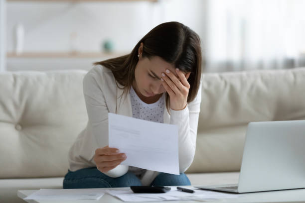 woman read bad news notification letter from bank about debt - unemployment fear depression women imagens e fotografias de stock
