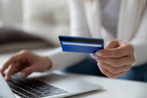 istock Closeup image female using laptop holding credit card makes payment 1251273789