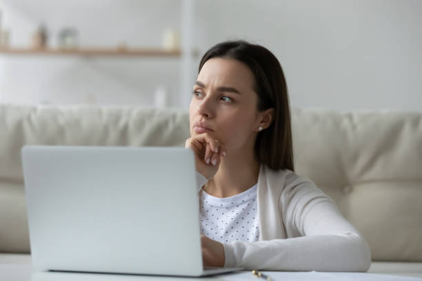 istock Pensive girl sit in front of laptop thinking over task 1251273825