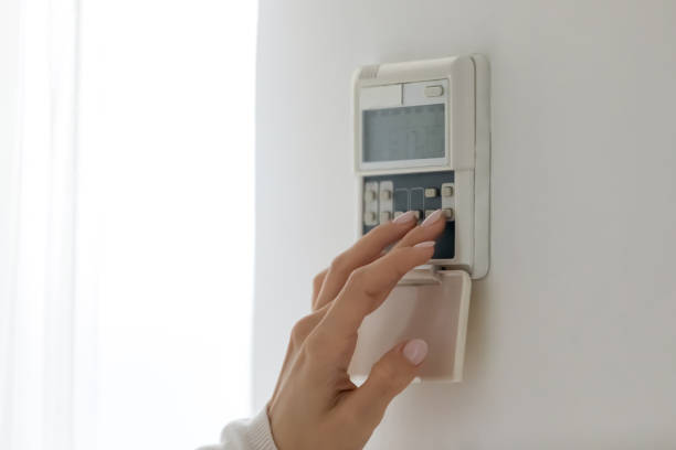 istock Female fingers set comfortable temperature at home use digital thermostat 1251273852