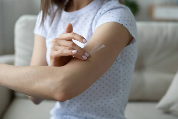 istock Woman applying cream on arm using natural treatment closeup view 1251273858