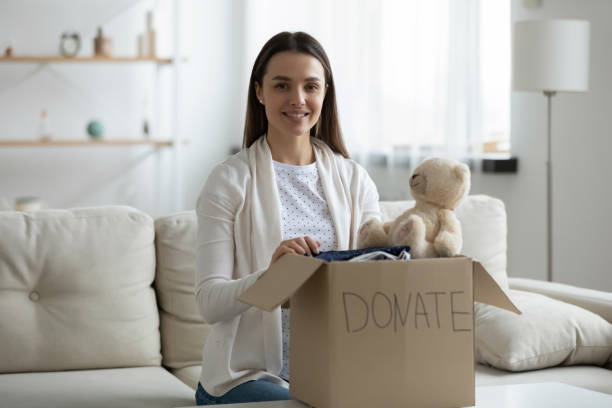 istock Woman prepare donation box with old stuff for charity 1251273864