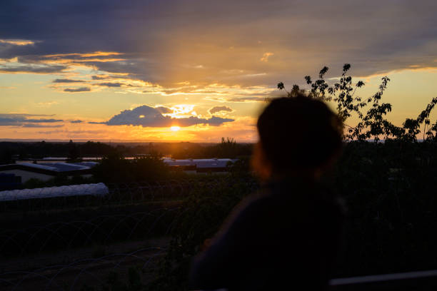 istock Person watching a dramatic orange sunset 1251273926