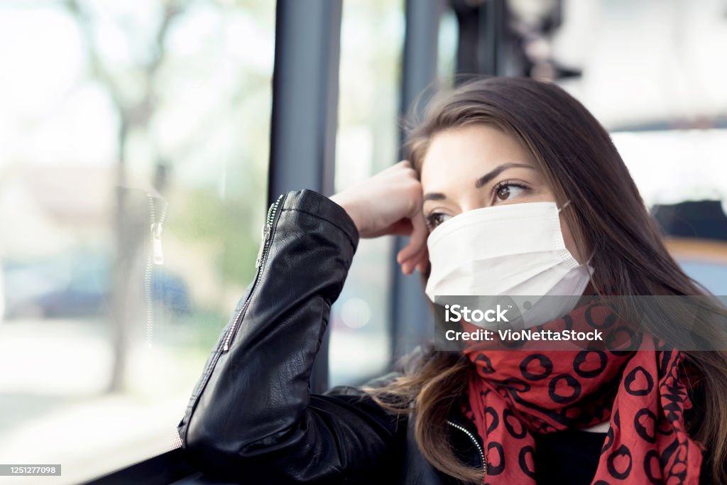 Young woman with protective mask stock image Young woman 20-25 years with protective mask and red scarf in a bus, close-up Adult Stock Photo