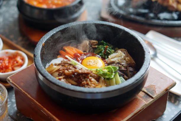 istock Dolsot bibimbap - Korean mixed rice, Include steamed rice, vegetables, pork and fried egg on top, served in a hot stone pot. 1251277169