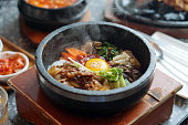 Dolsot bibimbap - Korean mixed rice, Include steamed rice, vegetables, pork and fried egg on top, served in a hot stone pot.