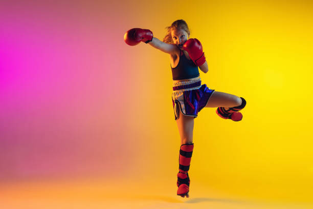 istock Little caucasian female kick boxer training on gradient background in neon light, active and expressive 1251280083