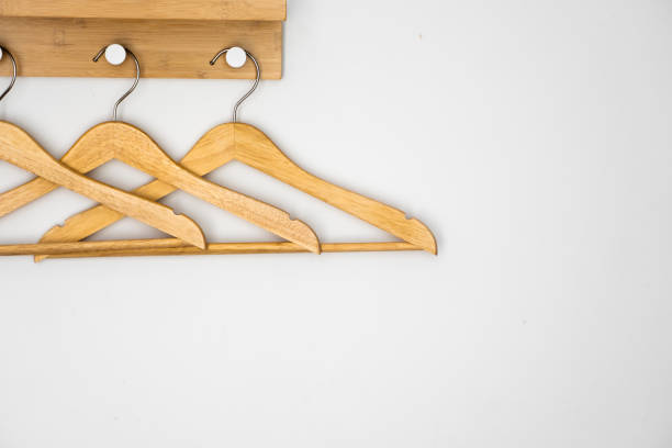 istock Clothes wooden hangers on a white wall. 1251280170