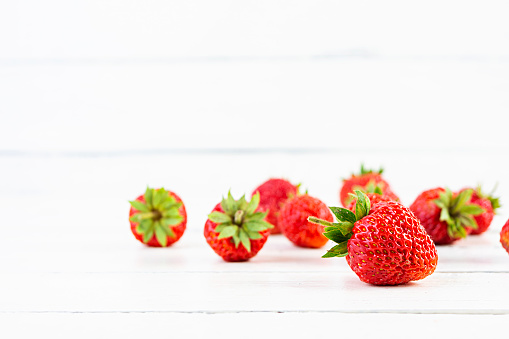Sweet fresh ripe strawberry isolated on white wooden background.