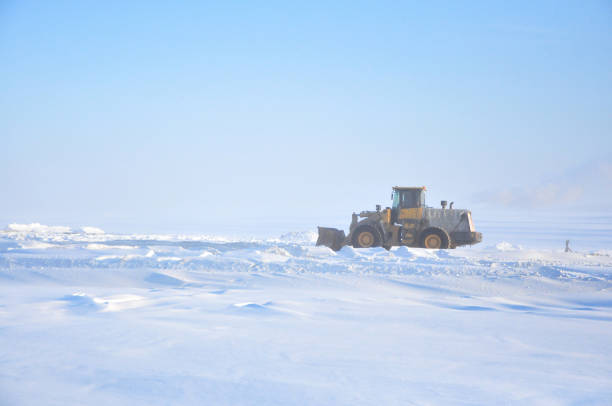 istock Grader clears snow on ice road on Lena river after storm 1251281134