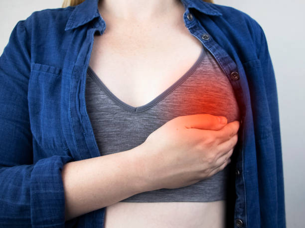 A woman suffers from chest pain. On examination by a gynecologist-mammologist. The concept of the prevention of breast diseases, cancer, mastopathy or hormonal disorders stock photo