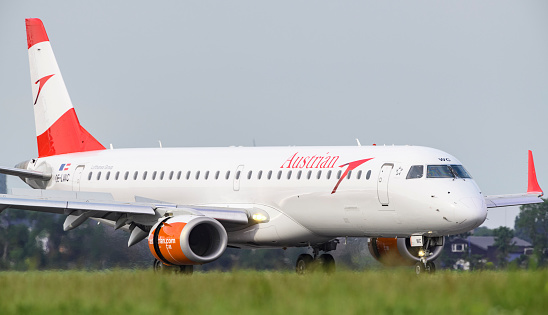 Austrian Airlines Embraer ERJ-195L landing at Schiphol Airport near Amsterdam. Austrian is the flag carrier of Austria and a subsidiary of the Lufthansa Group and is based at Vienna International Airport in Schwechat.
