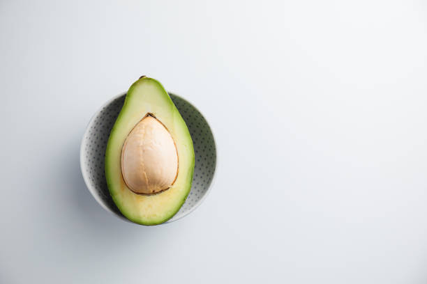 Avocado on a plate and on a white background. Minimum concept