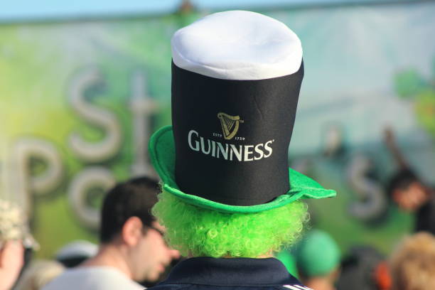 portrait of excited man holding glass of beer on St.Patrick's day on black