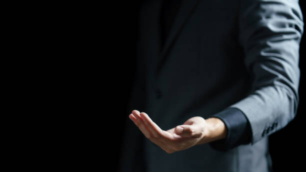 istock Business man open empty hand on black background. 1251284469
