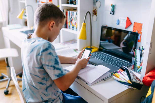 education at home.teenager learning using mobile phone and laptop. - homework teenager mobile phone school imagens e fotografias de stock