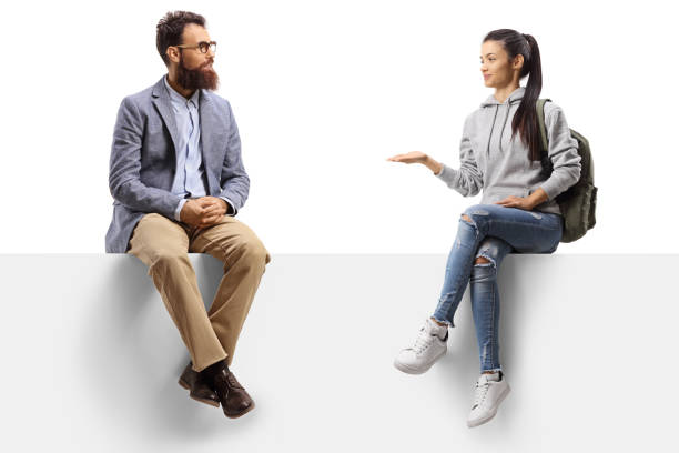 istock Female student sitting on a panel gesturing with hand and talking to a bearded man 1251285821